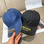 Pair of Prada baseball caps: black and blue with gold “PRADA MILANO” logos
