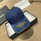 Prada cap in blue with yellow “PRADA MILANO” logo on the front panel.