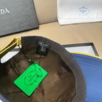 Prada cap interior view with black lining and green tag attached near the brim.
