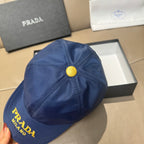 Prada cap in blue with top button and visible seam detailing across the crown.
