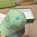 Gucci turquoise cap showing top panel seam and GG logo pattern, teal button