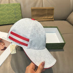 Gucci cap, white GG monogram with red stripe; handheld view of the front and brim.