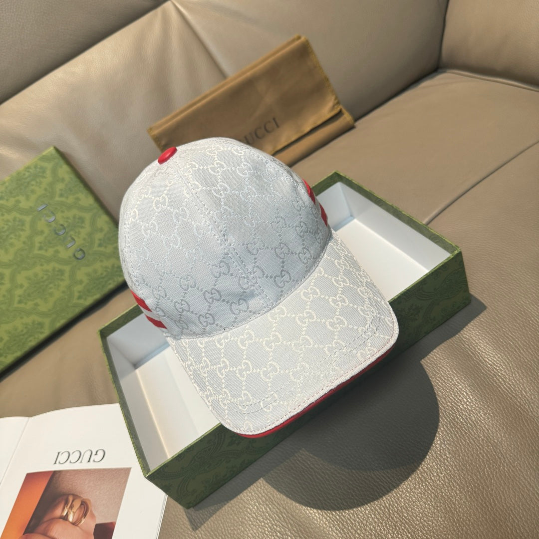 Gucci cap with white GG monogram print, red-and-blue stripe, and curved brim.
