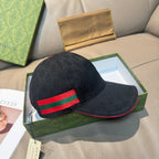 Black GG-pattern baseball cap with red and green Web stripe; curved brim visible.