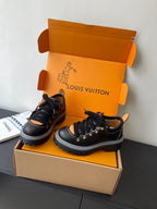 Louis Vuitton ladies sneakers: black lace-up with gold accents, fur collar, rugged rubber sole