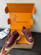 Louis Vuitton women's sneakers, angled view of dark purple pair with purple laces and tan sole
