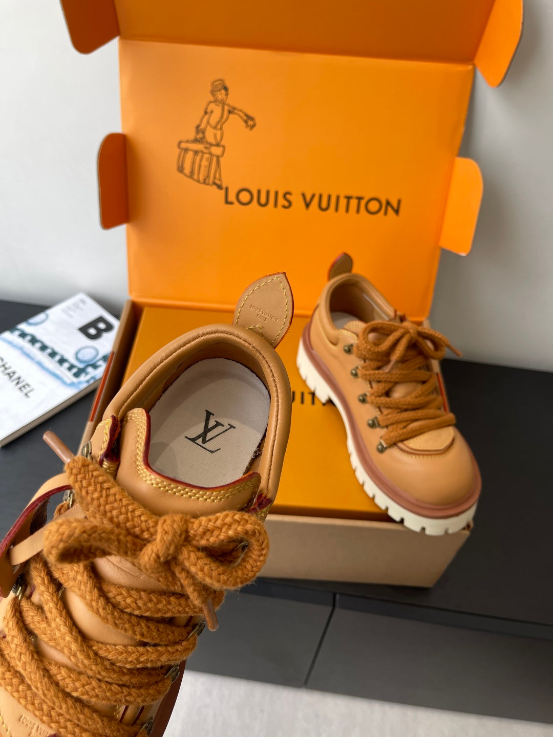 Women’s Louis Vuitton tan leather sneakers close-up, lace and brand logo detail.