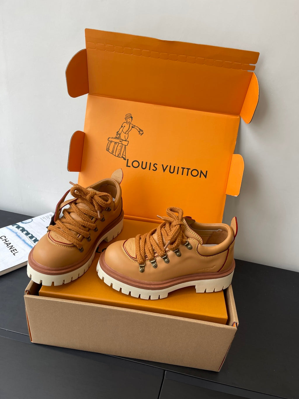 Women’s Louis Vuitton tan lace-up sneakers pair on display, 3/4 view.