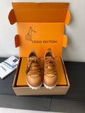 Women’s Louis Vuitton tan lace-up sneakers with chunky white tread sole.
