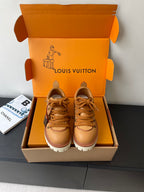 Women’s Louis Vuitton tan lace-up sneakers with chunky white tread sole.
