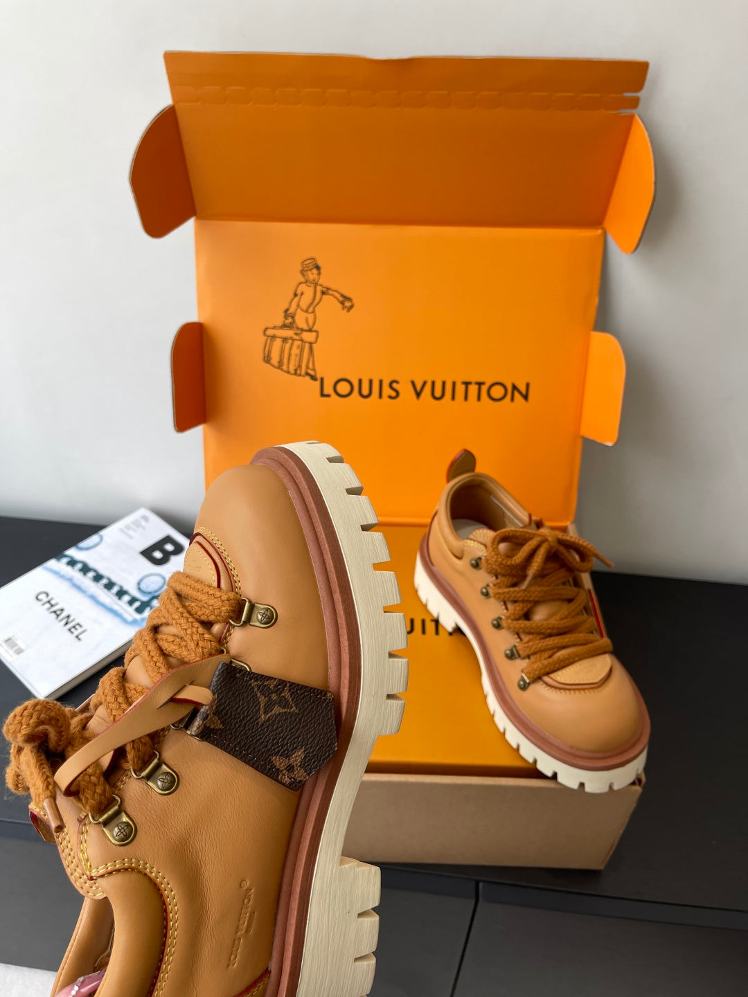 Women’s Louis Vuitton tan lace-up sneakers with side monogram pattern detail.