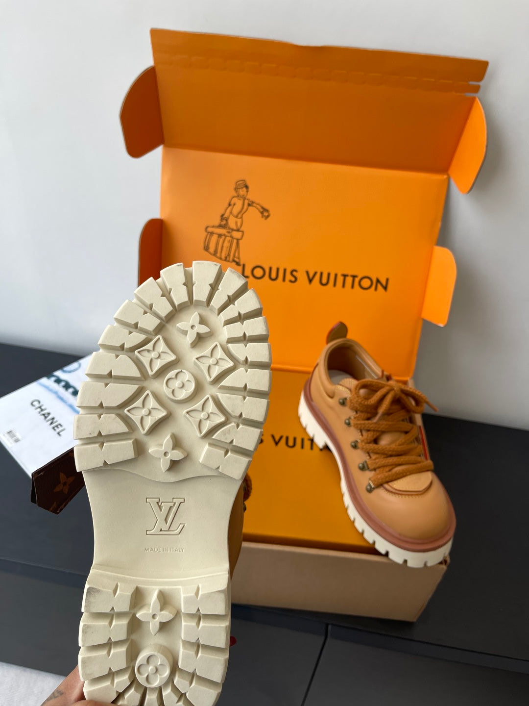 Women’s Louis Vuitton tan lace-up sneakers with star-pattern white rubber outsole.