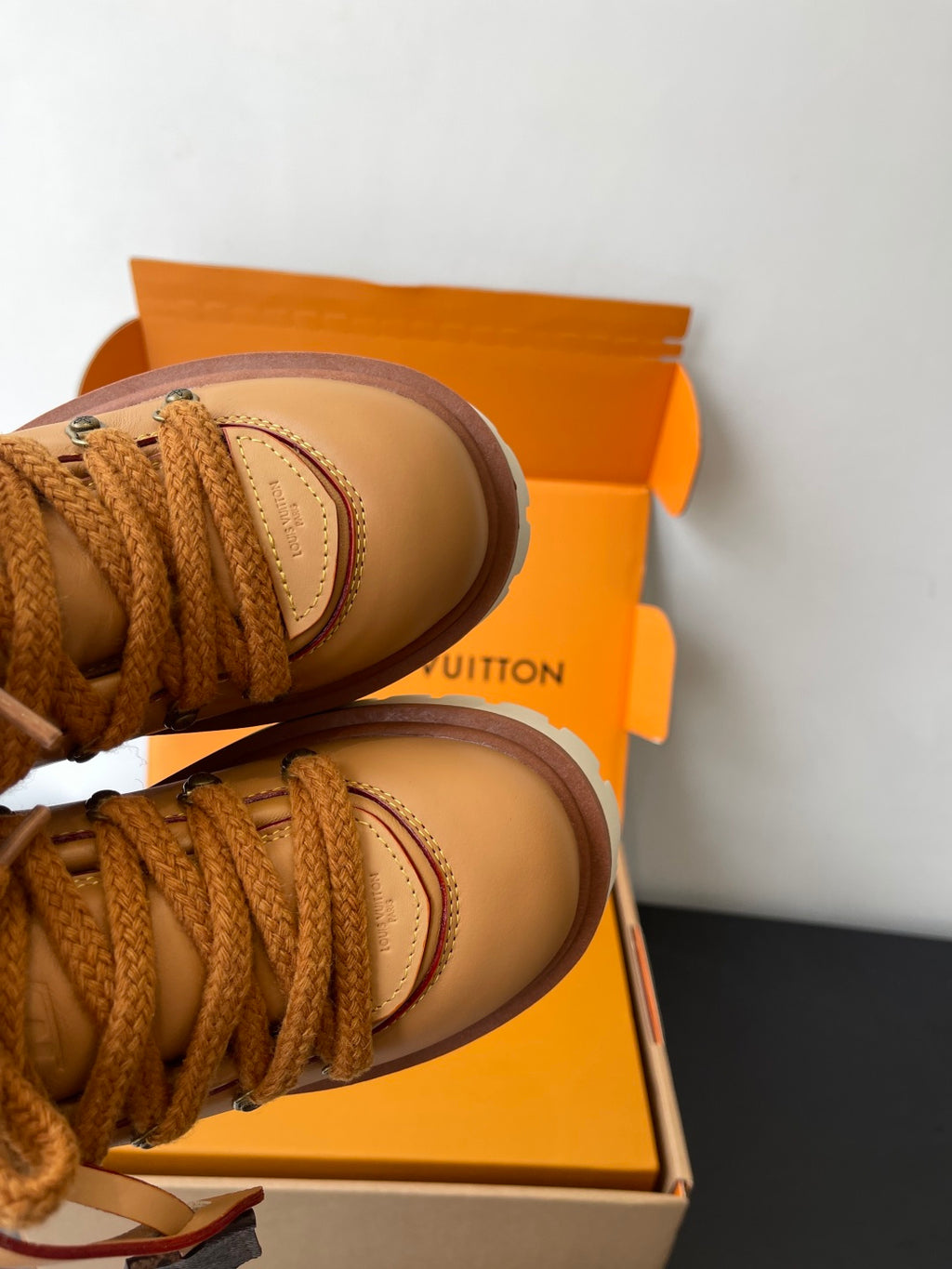 Women’s Louis Vuitton tan lace-up sneakers, close-up of toe and lace trim.