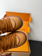 Women’s Louis Vuitton tan lace-up sneakers, close-up of toe and lace trim.