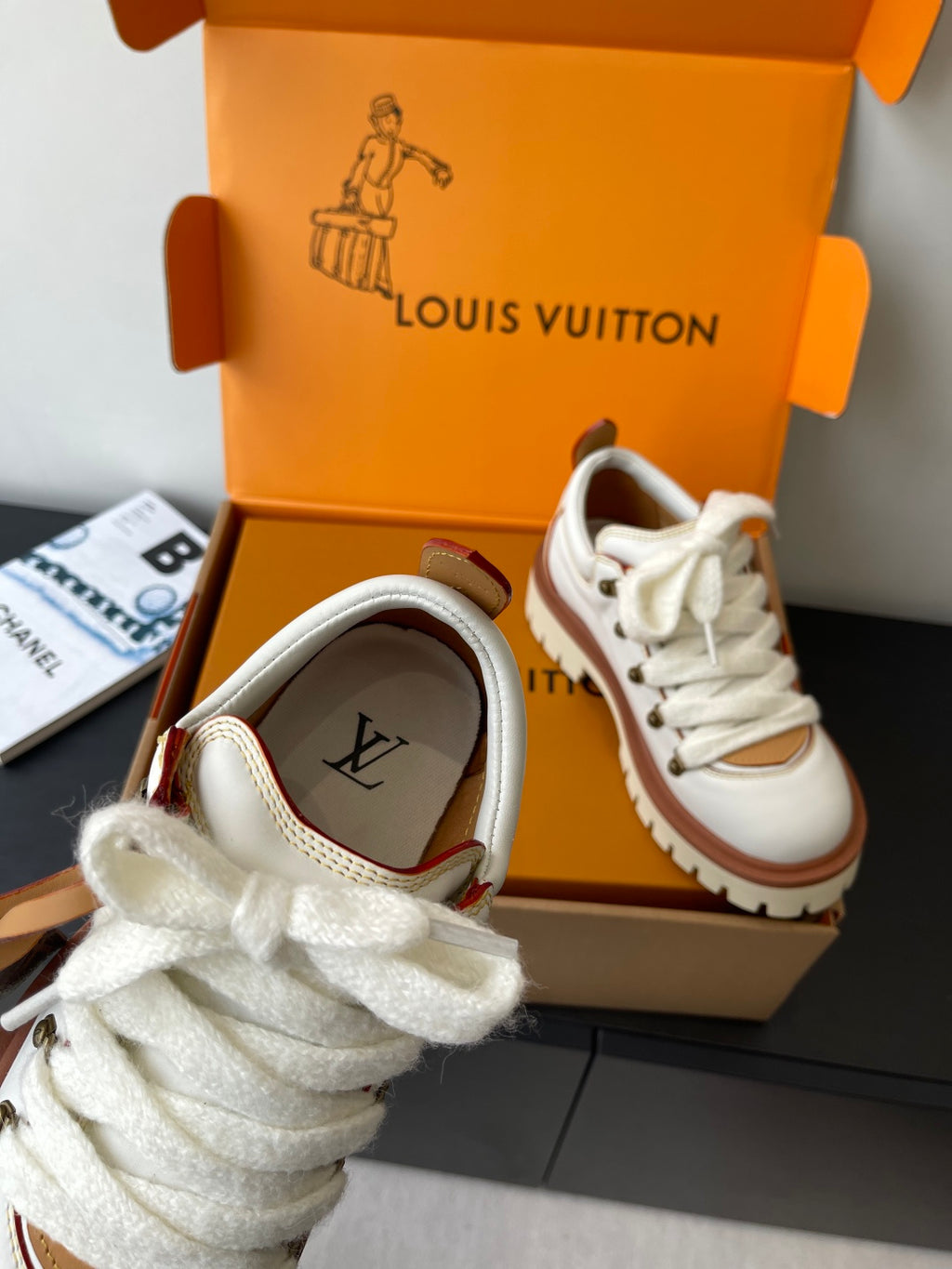Louis Vuitton women's sneaker with white upper, brown inner logo patch, laces