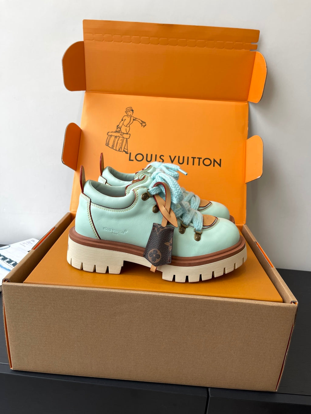 Women's mint sneakers with blue laces, brown side panels, and treaded sole