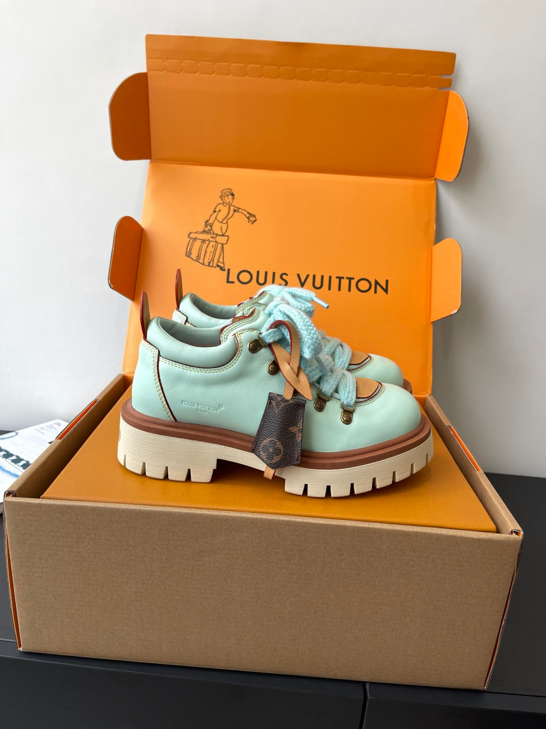 Women's mint sneakers with blue laces, brown side panels, and treaded sole
