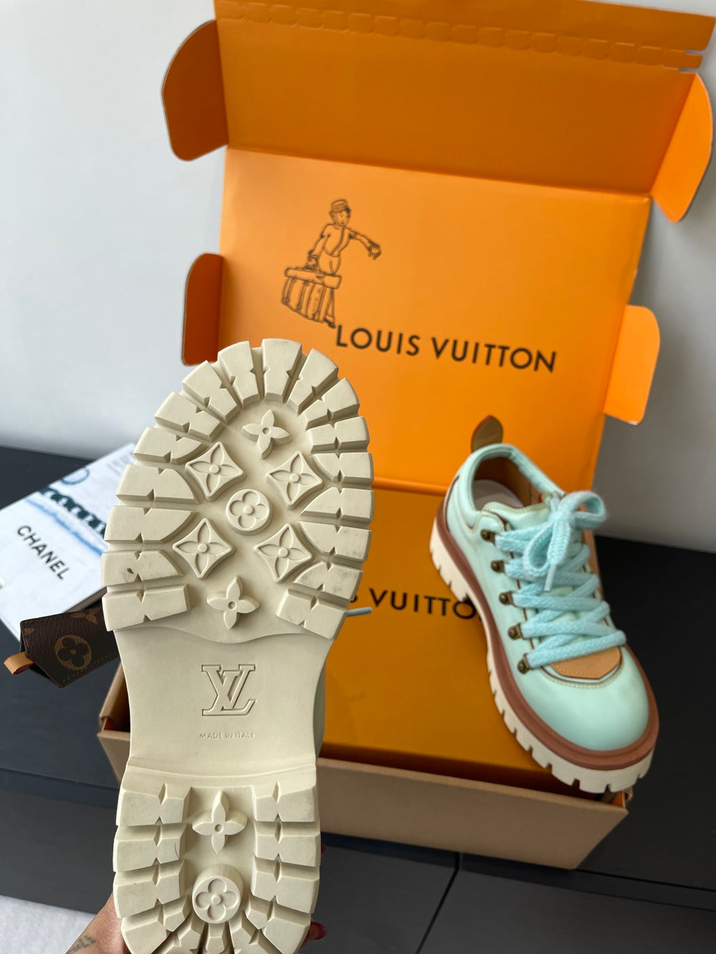 Women's mint sneaker with treaded outsole details and blue laces, in box