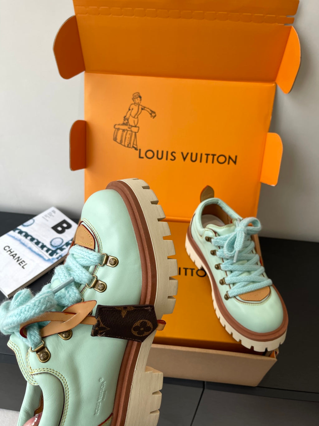 Women's mint sneakers with brown strap details and blue laces, in box