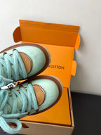 Women's mint sneakers with blue laces, brown trim, side view in box