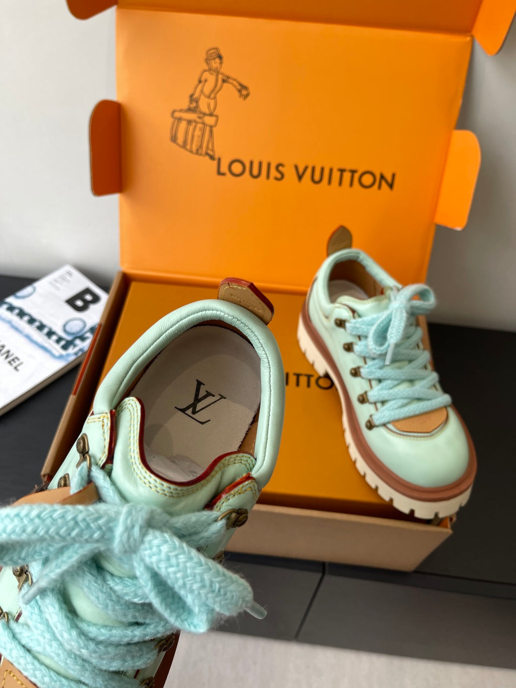 Women's mint sneaker close-up with blue laces, brown collar trim, LV logo