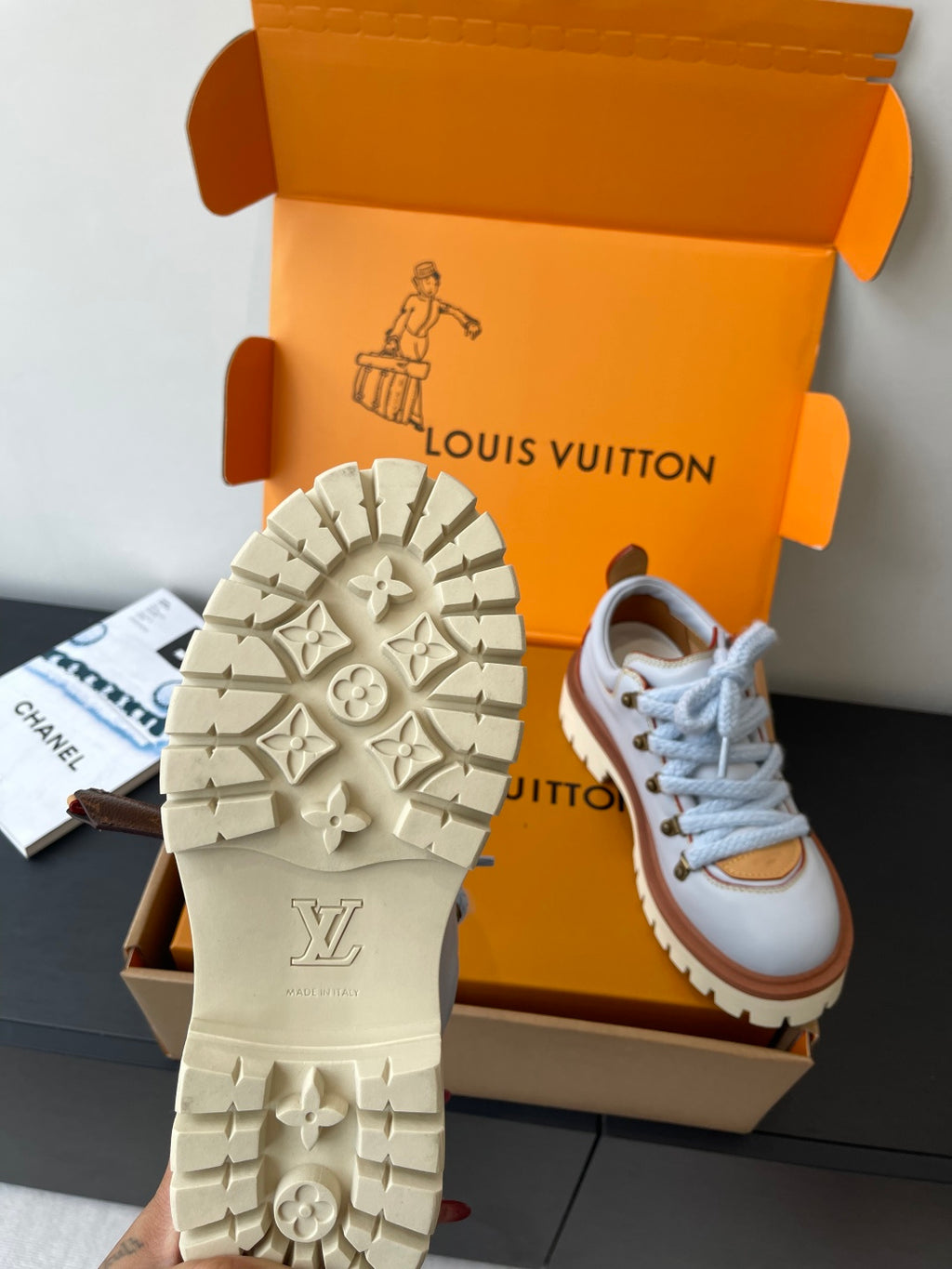 Women's sneaker outsole tread with logo detail, pair shown in box