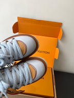 Women's white sneakers with blue laces and tan leather side trim