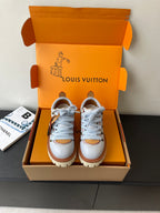 Women's white sneakers with blue laces, brown trim, chunky rubber sole
