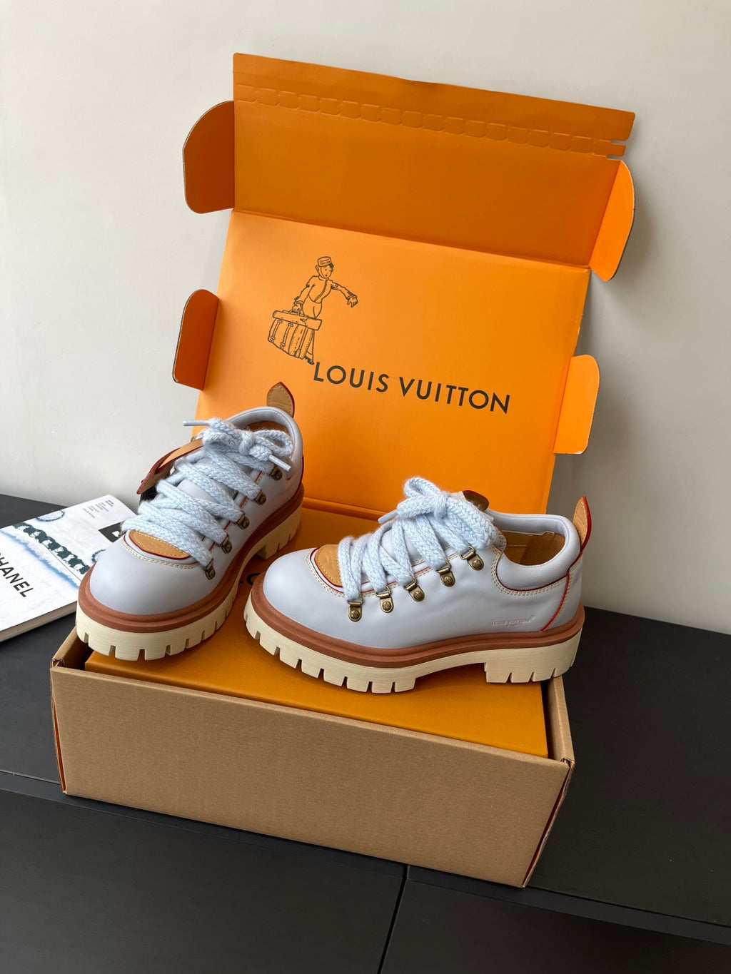 Women's white sneakers with blue laces, brown trim, thick lug sole