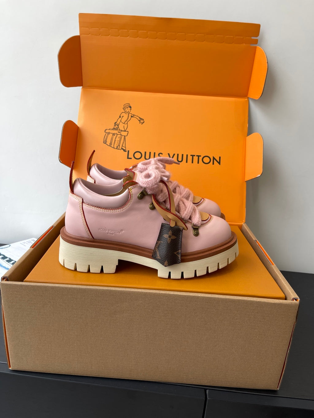 Pink Louis Vuitton sneakers, side view with lace-up closure and brown monogram panel