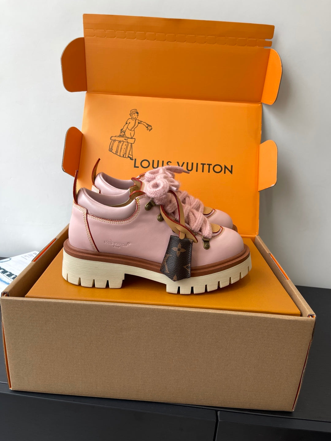 Pink Louis Vuitton sneakers, side view with lace-up closure and brown monogram panel