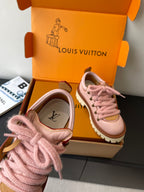 Pink Louis Vuitton sneakers close-up on toe and laces with tan trim and brown details