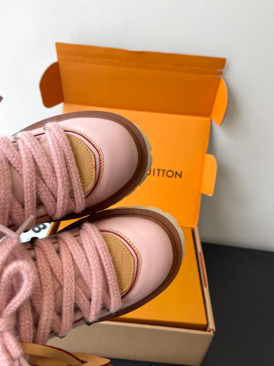 Pink Louis Vuitton sneakers close-up of toe cap and lace with tan edge trim