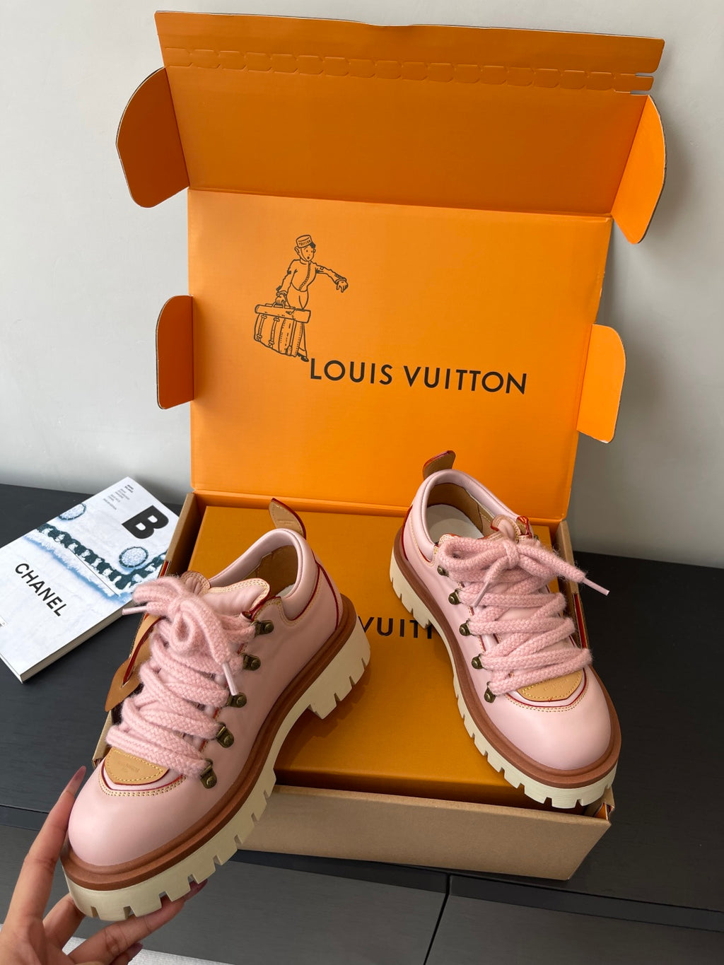 Pink lace-up Louis Vuitton sneakers, angled view with tan trim and white sole