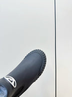 Dark navy ankle boot toe and textured rubber sole with deep tread