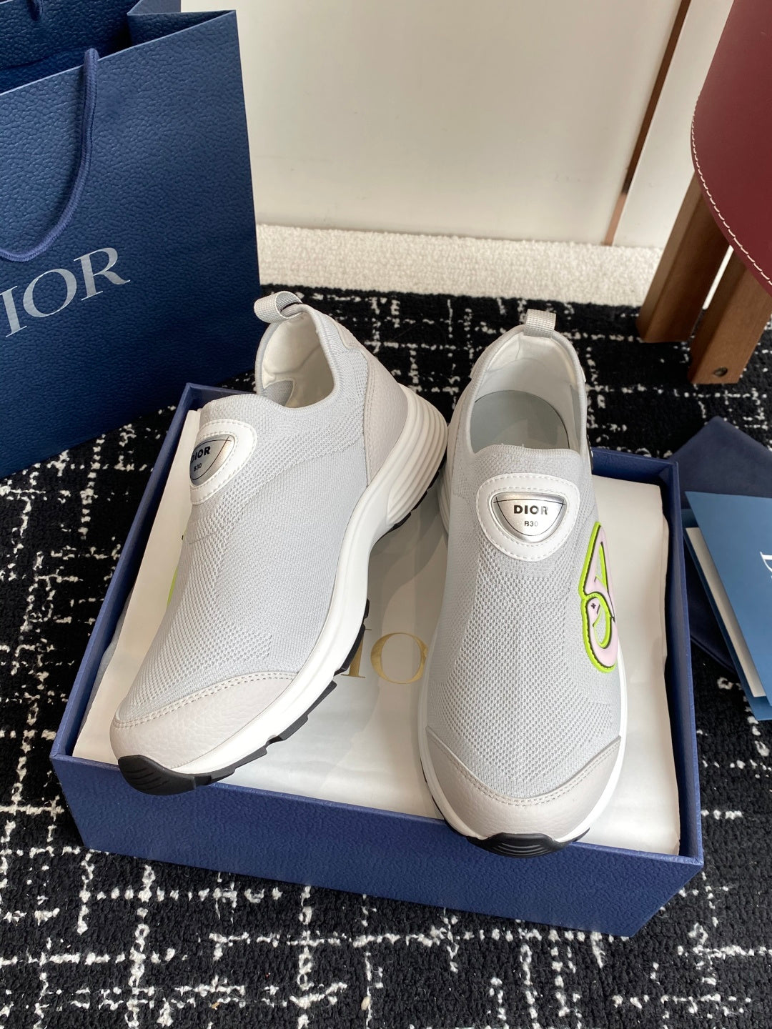White slip-on sneakers with neon-green logo, thick rubber sole and Dior label