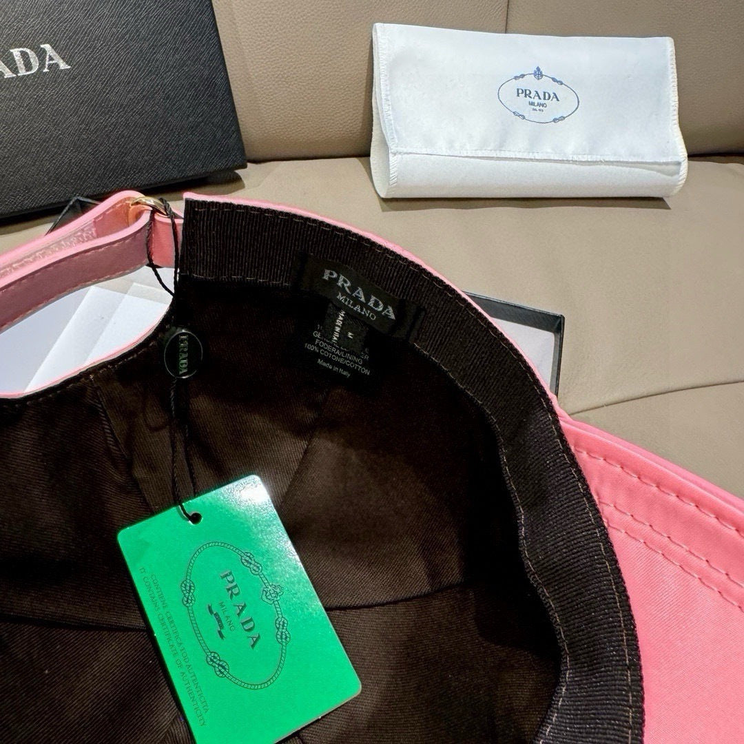 Prada cap inside view with black interior and pink brim, green tag attached.