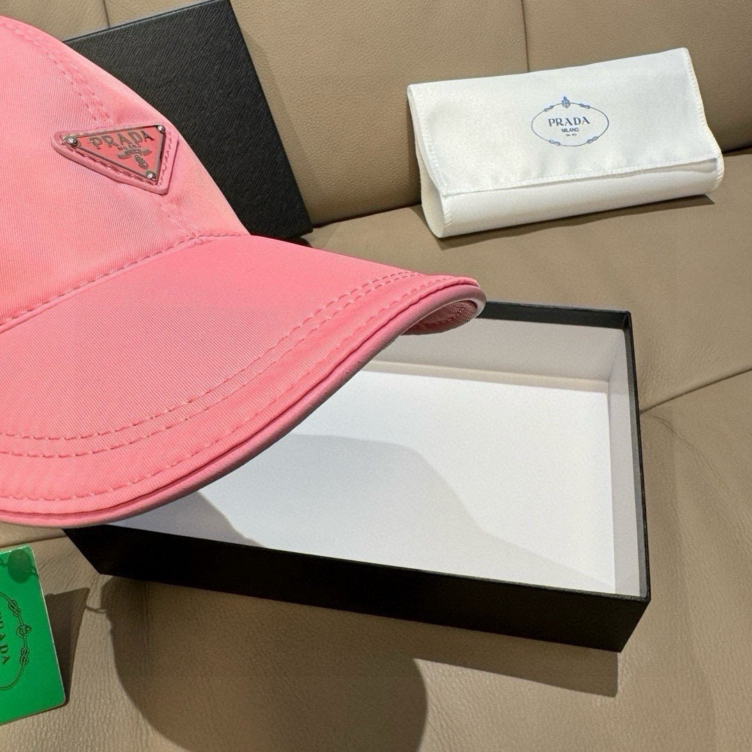 Prada pink cap close-up of brim edge and triangular logo patch, stitched crown.