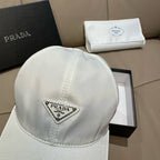 White baseball cap with Prada logo triangular patch on front.