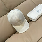 White baseball cap with Prada logo patch on side panel and curved brim.