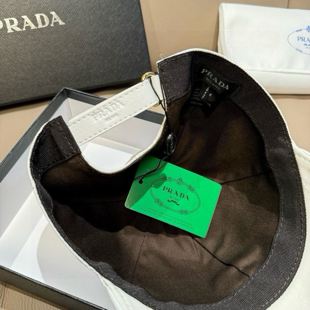 Black baseball cap with white under-bill and Prada labels plus green tag.