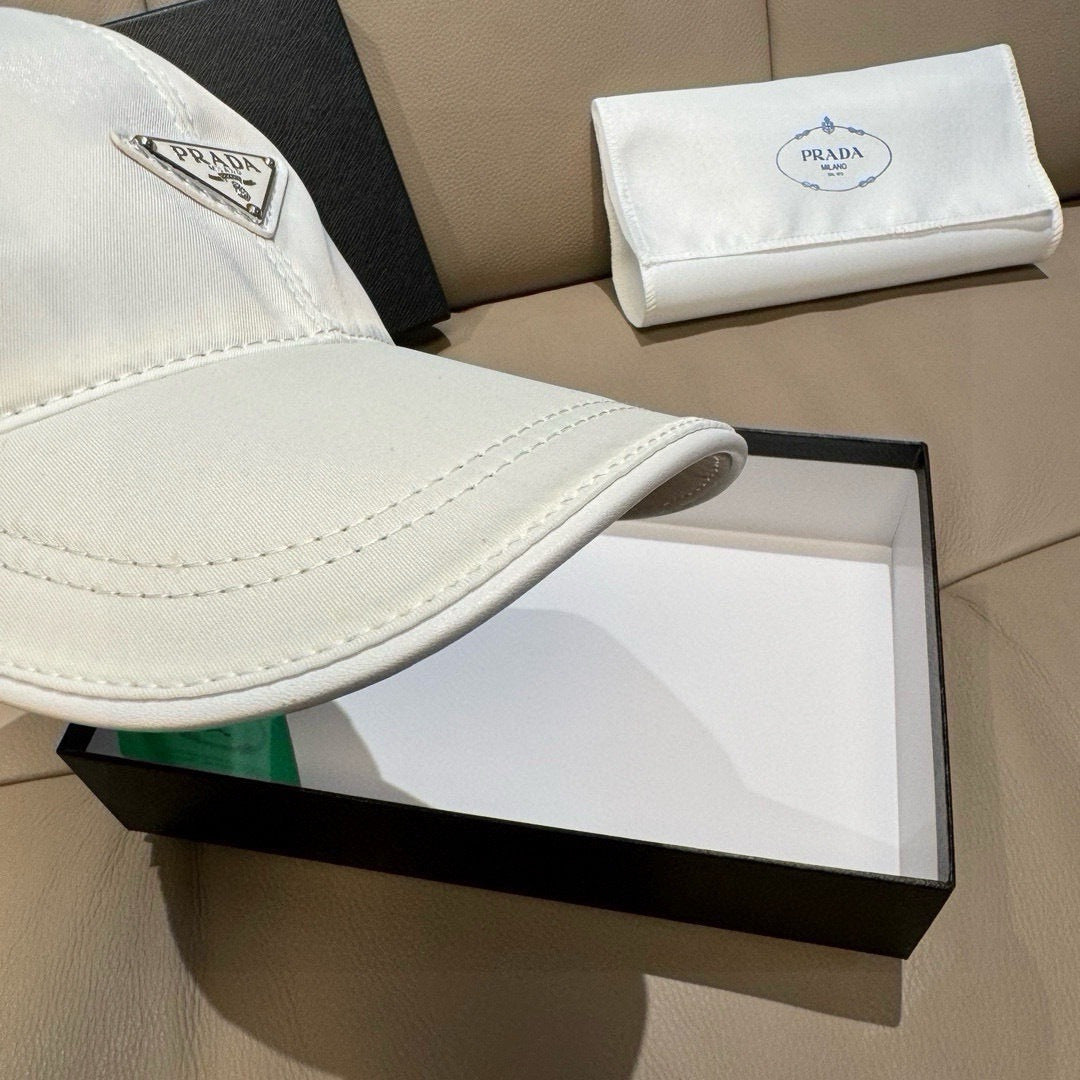 White baseball cap brim with visible stitching and Prada logo patch.
