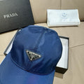 Prada baseball cap in dark blue satin fabric, triangular logo patch on front.