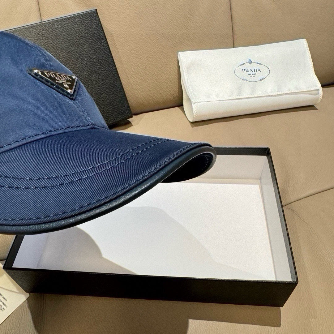 Prada dark blue baseball cap brim detail with stitched edge and triangular logo patch.