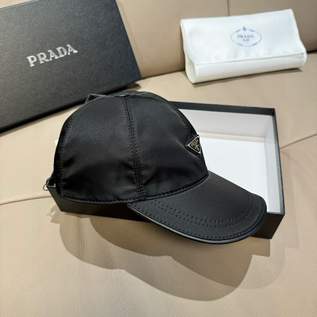 Black baseball cap with curved brim and side Prada triangular logo patch, side view.