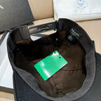 Black baseball cap interior with adjustable strap and printed Prada label.
