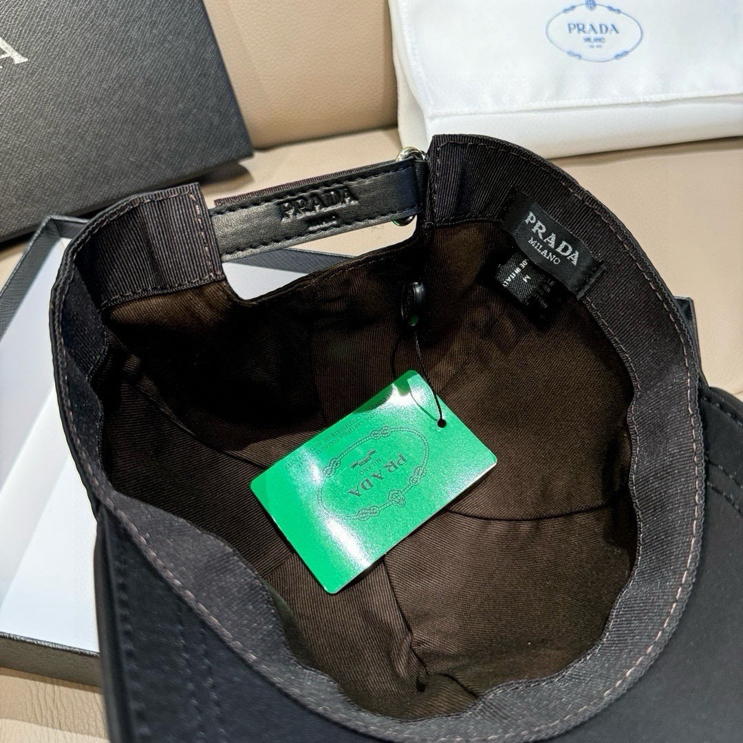 Black baseball cap interior with adjustable strap and printed Prada label.