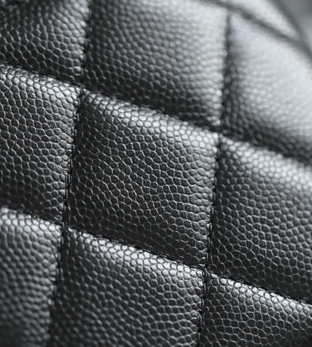 Close-up of black quilted leather panel with stitched seams
