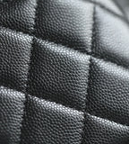 Close-up of black quilted leather panel with stitched seams