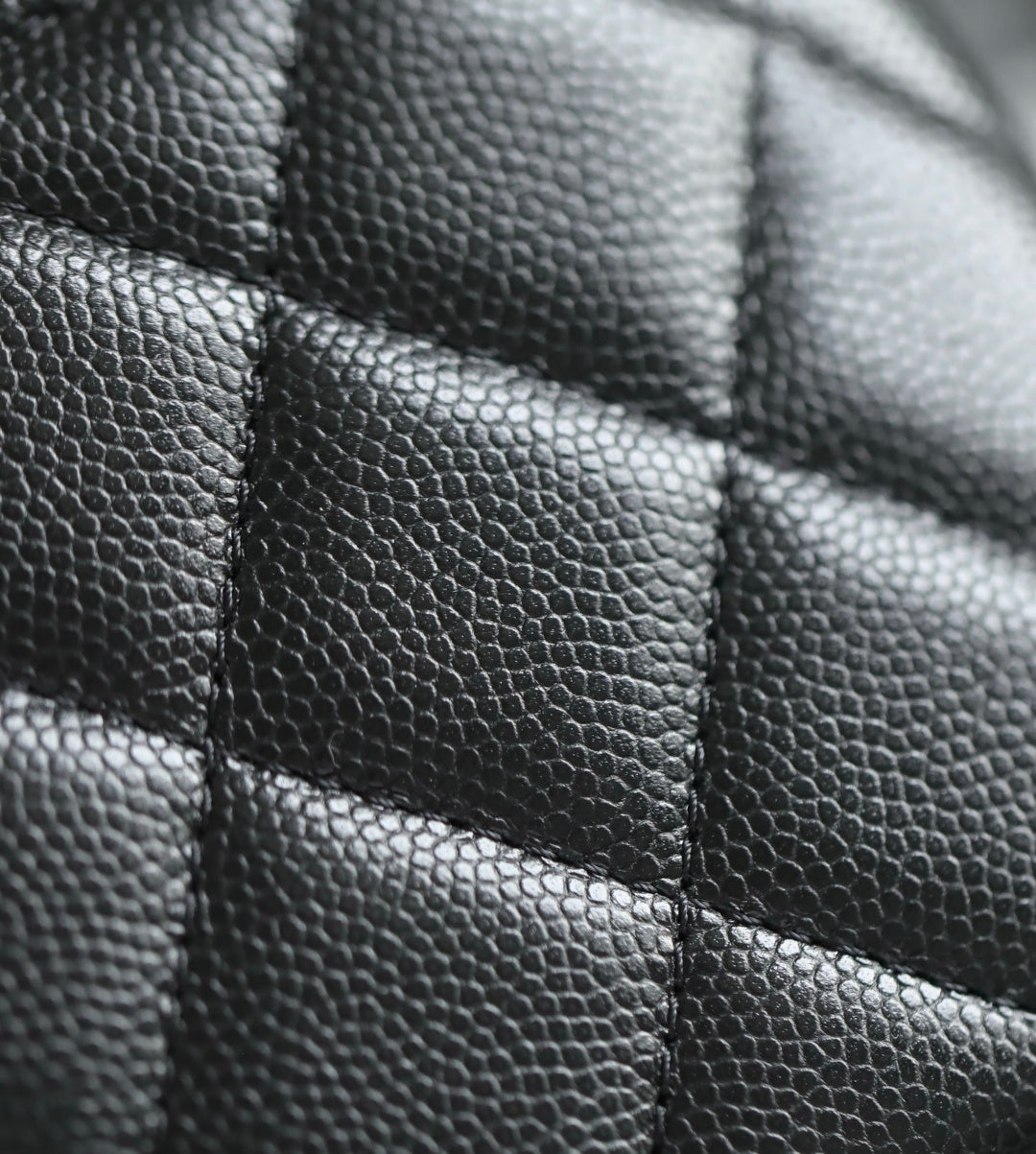 Close-up of black quilted leather panel with stitched seams